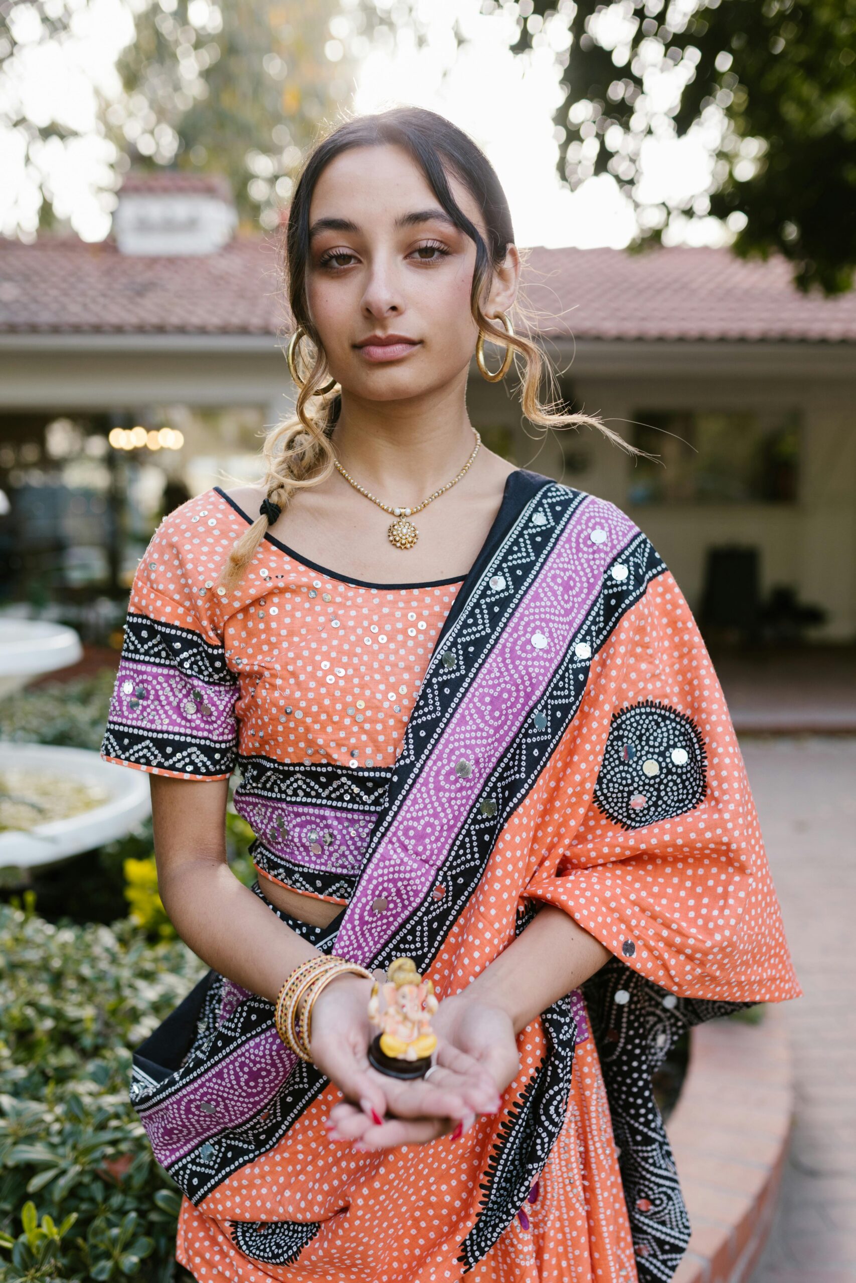 Woman in orange black and purple standing